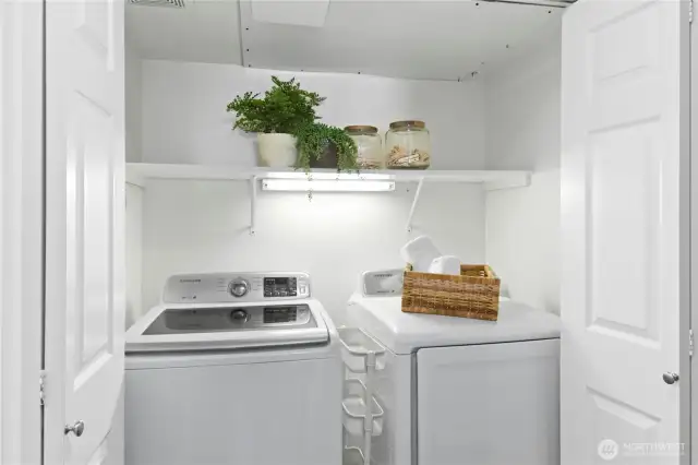 Convenient, in-unit full size, side-by-side washer and dryer with additional storage space, tucked behind bi-fold doors.