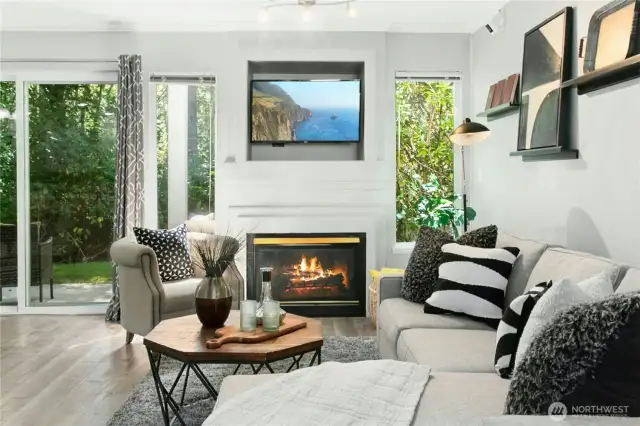Spacious living room with large windows, crown molding, and a warm gas fireplace - perfect for relaxing or entertaining in your Klahanie retreat.