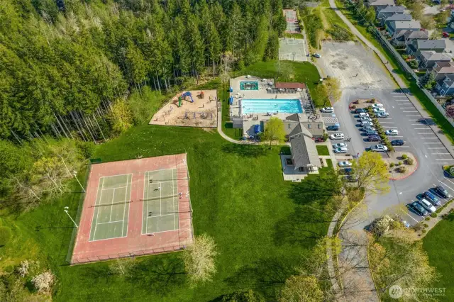 Aerial view of Klahanie’s Mountain View Park, featuring tennis courts, a playground, swimming pool, hot tub, clubhouse, and open green space, all surrounded by lush Pacific Northwest forest. Everyday essentials are just two minutes away at the Klahanie Shopping Center, home to QFC, dining options, a hair salon, dry cleaner, veterinary clinic, medical offices, and more.