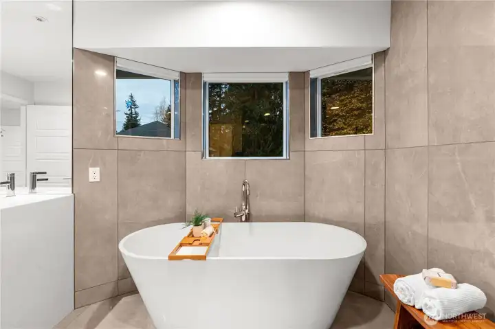 Freestanding tub surrounded by custom tile work