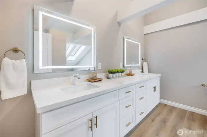 Large dual-vanity setup offers ample storage, quartz countertops, and everyday functionality designed for busy households.