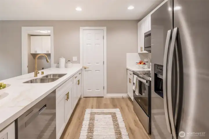 Fully remodeled kitchen features quartz countertops, stainless steel appliances, new cabinetry, and a functional layout designed for high-traffic, everyday use.