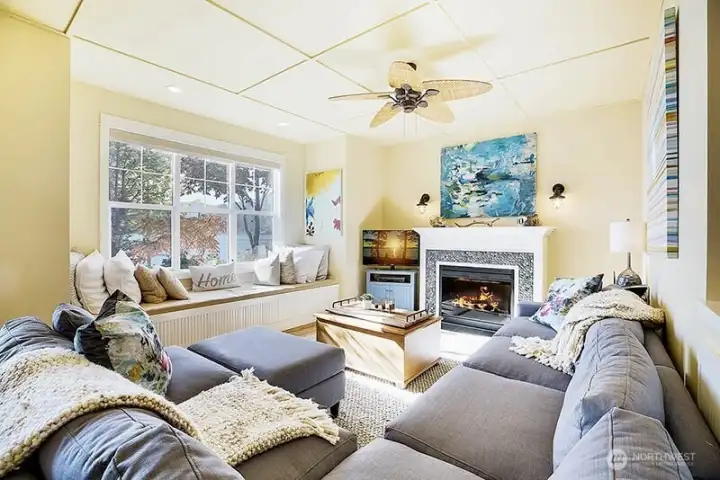 Gathering room features fireplace & window seat.