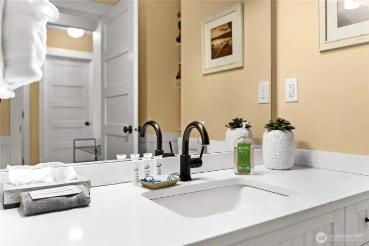 Remodeled bath.  Quartz counters, undermount sink & black faucets.