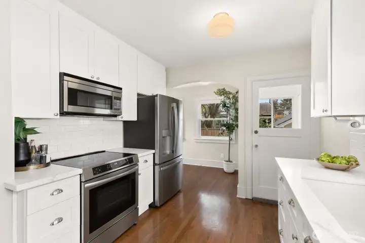 Just past the fridge is the perfect eating nook or sitting area. It could easily fit a table, desk, chair, you name it. The current owners used it as an office! The stairs to go up are located just beyond the light-filled nook.