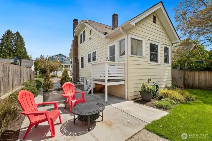 The owners sectioned off a part of the driveway to create a patio space, currently staged as a firepit. Bring your table here - the entrance to the kitchen/mudroom is just up those stairs.