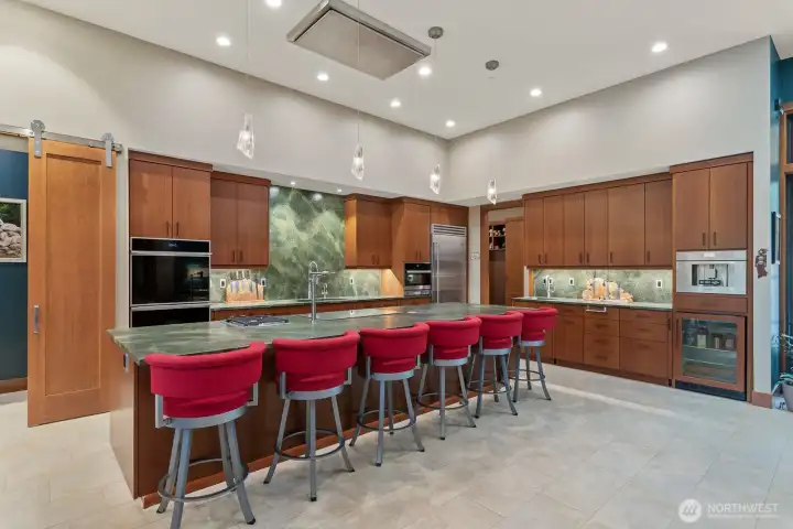 Gourmet kitchen any chef would approve.  Sapele cabinets with built in step ladders in multiple areas, high end appliances, huge island with conduction and gas stove tops, double ovens all laid out for function, entertaining and beauty.