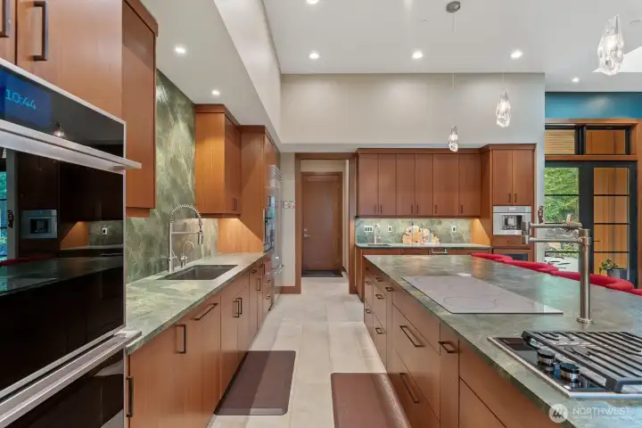Pot filler between the cooktops.  Door at end leads to walk in pantry, garage and too the left back hall with built in storage, door to back yard, 3/4 bath and access to primary suite through laundry/walk in closet.