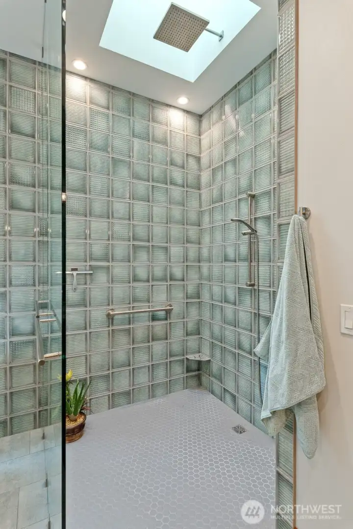 Custom shower with multiple shower heads, built in bars and shelves is stunning and  wheel chair accessible.