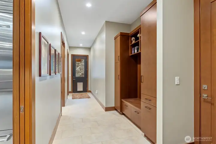 Back hall off kitchen and garage.  Custom bench/storage area.  Door with dog access leads to dog pen.  Second door on left is for 3/4 bath.