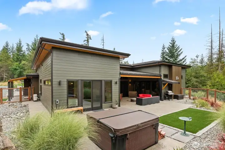Property is entirely fenced for you and your pets.  Artificial turf areas, native and natural landscaping for easy maintenance and enjoyment. Fenced area on left is dog pen area.