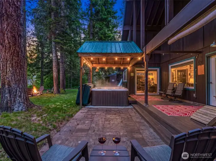 Hot tub, outdoor seating, and fire pit area surrounded by mature evergreens. A private setting designed for relaxing, entertaining, and enjoying the outdoors year-round. Hot tub, outdoor seating, and fire pit area surrounded by mature evergreens. A private setting designed for relaxing, entertaining, and enjoying the outdoors year-round.