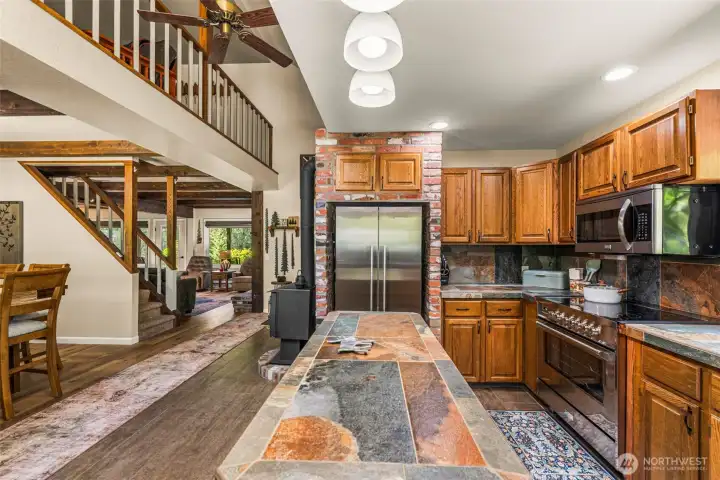 an open connection to the dining area create an inviting gathering space, while large windows frame peaceful forest views and bring the outdoors in. an open connection to the dining area create an inviting gathering space, while large windows frame peaceful forest views and bring the outdoors in.