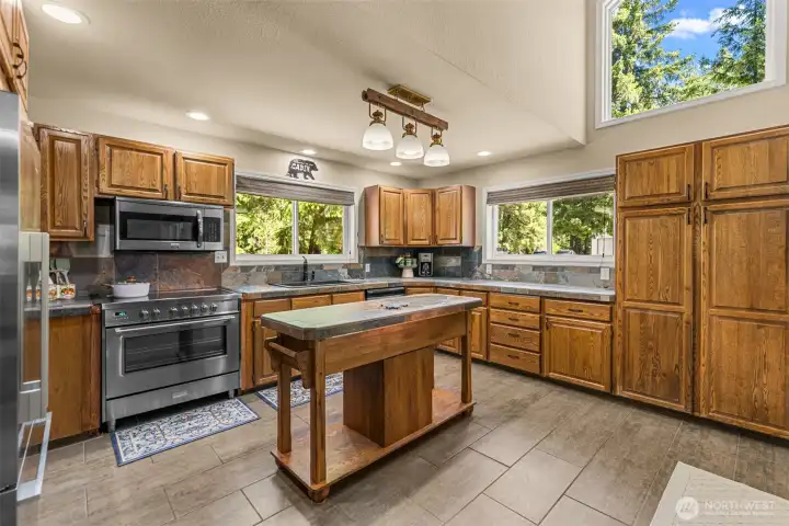 Generous storage, extensive workspace, tile surfaces, stainless appliances, and a center island. Generous storage, extensive workspace, tile surfaces, stainless appliances, and a center island.
