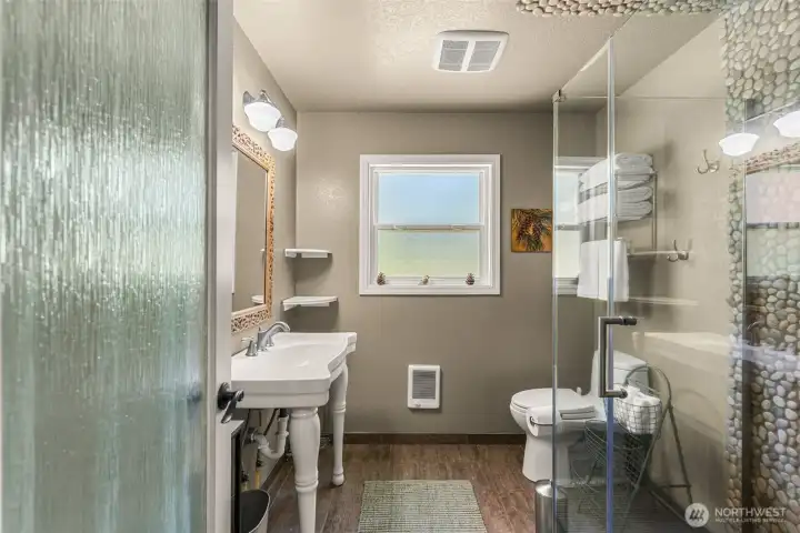 Updated bathroom with a walk-in tile and river rock shower, glass enclosure, natural light, and warm mountain-inspired finishes. Updated bathroom with a walk-in tile and river rock shower, glass enclosure, natural light, and warm mountain-inspired finishes.