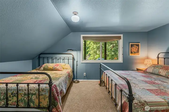 Inviting guest bedroom with forest views, and ample space for multiple sleeping arrangements. Inviting guest bedroom with forest views, and ample space for multiple sleeping arrangements.