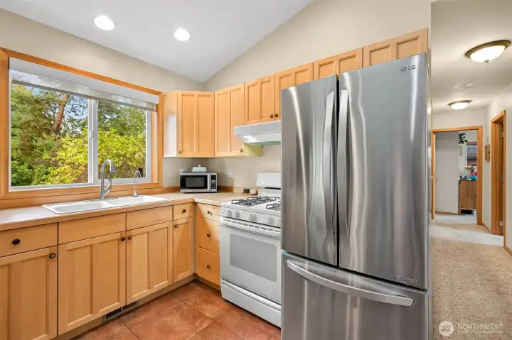 Stainless steel appliances and abundant cabinetry are complemented by large windows overlooking the surrounding trees, bringing natural light into the space. Stainless steel appliances and abundant cabinetry are complemented by large windows overlooking the surrounding trees, bringing natural light into the space.