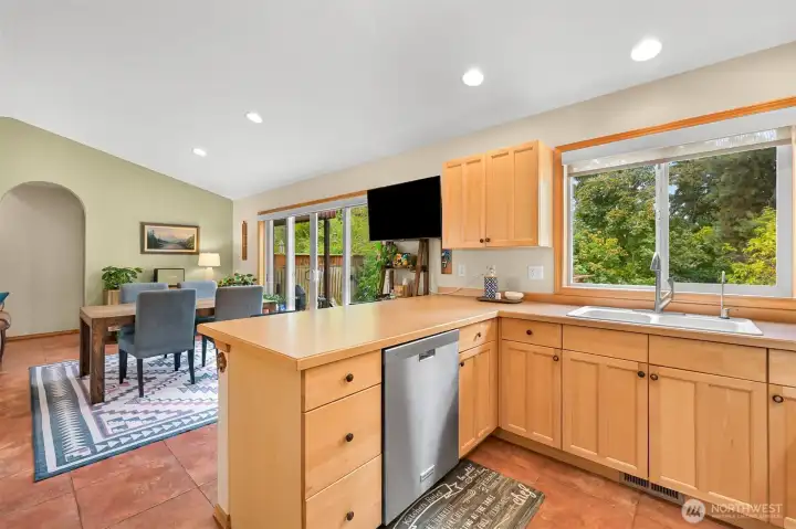 Open sightlines between the kitchen, dining area, and deck beyond make indoor-outdoor entertaining effortless. Open sightlines between the kitchen, dining area, and deck beyond make indoor-outdoor entertaining effortless.