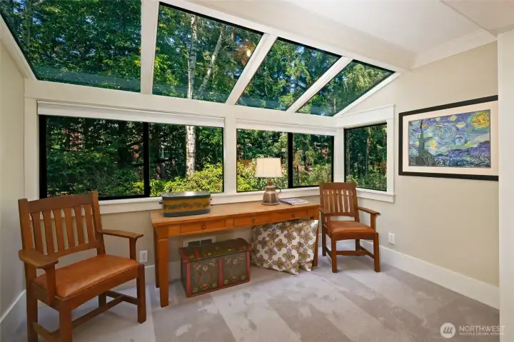 Master bedroom seating area looks out to lush gardens.
