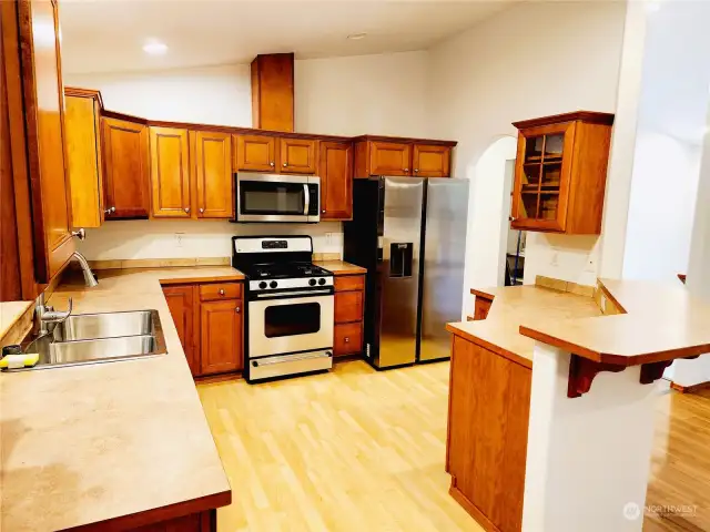 Open kitchen with breakfast bar and brand new sink and refrigerator