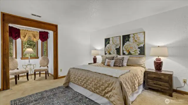 Primary bedroom with bow window. Have a nice cup of tea or enjoy a nice book in front of it!