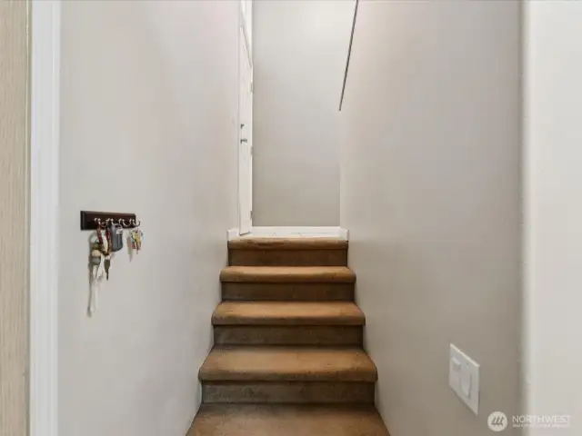 Base of the stairs with entrance to garage just to the left