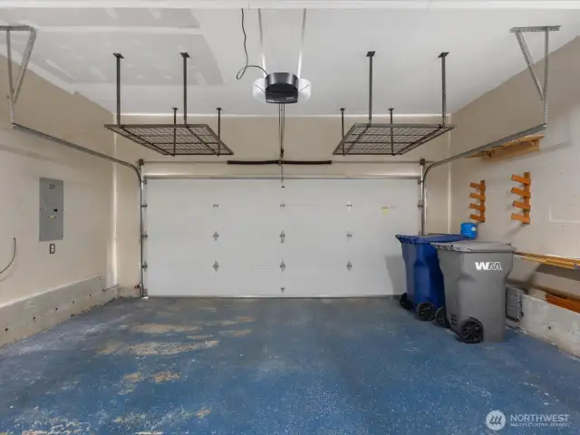 View from entry of garage to car door, overhead storage system stays with home to help keep organized & accessible