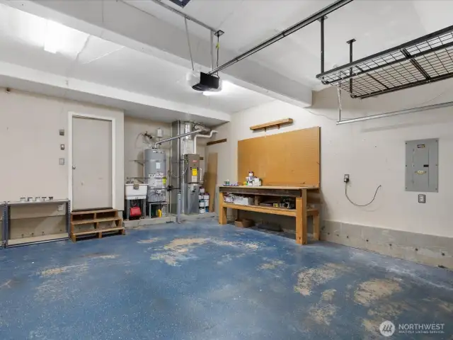DIY enthusiast's dream, garage is equipped with workbench, pegboard & utility sink