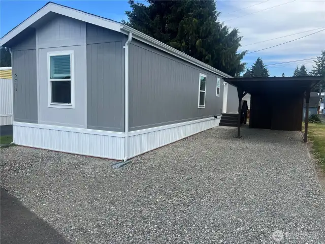Side view of the home with carport and shed.