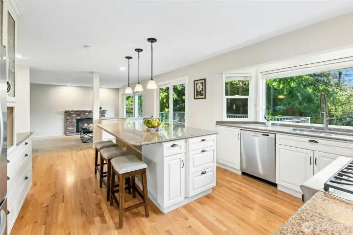 Gorgeous island kitchen with slab granite counters, white cabinets.