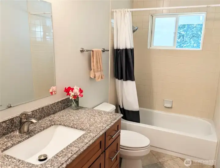 The guest bath was recently updated with travertine tiles and a new vanity with granite top and undermounted sink.
