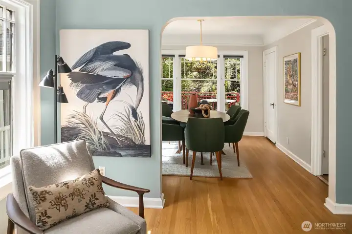 A wide coved doorway leads from the living room to the dining room. The door to the upstairs is on the far right.