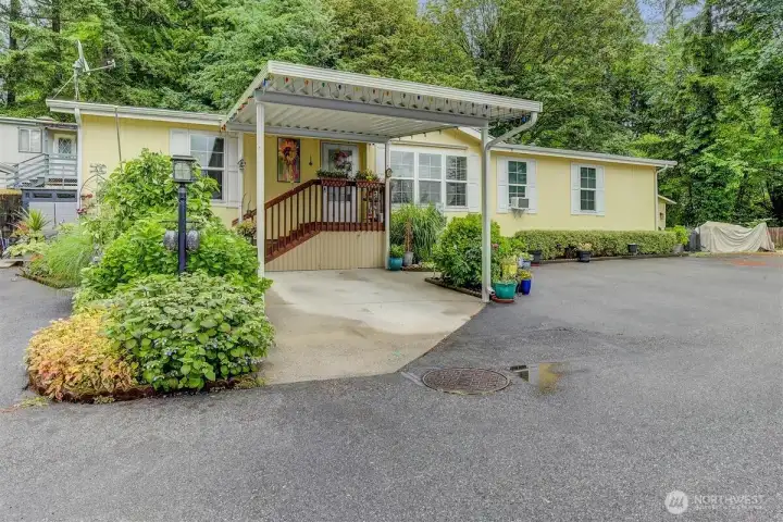 Adorable and welcoming with a covered porch and an abundance of plants surrounding. Convenient carport. Adorable and welcoming with a covered porch and an abundance of plants surrounding. Convenient carport.