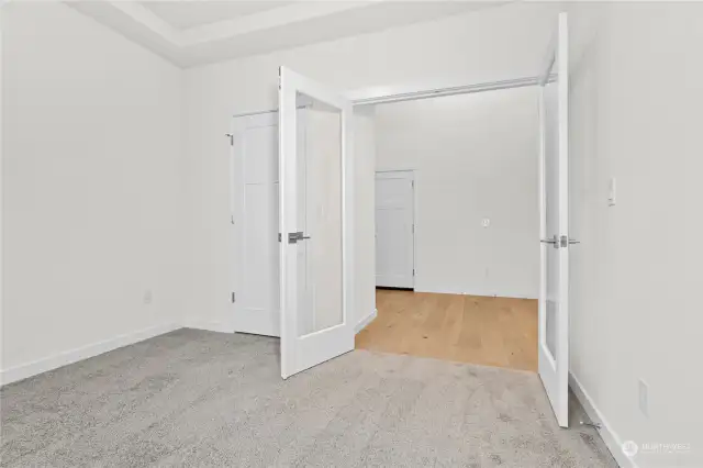 Clear glass entry doors lead to den/office or 3rd bedroom option. Photo for illustration only of similar home, not actual.