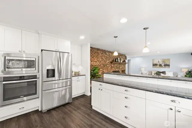 Kitchen with luxury vinyl plank flooring adjacent to the family room