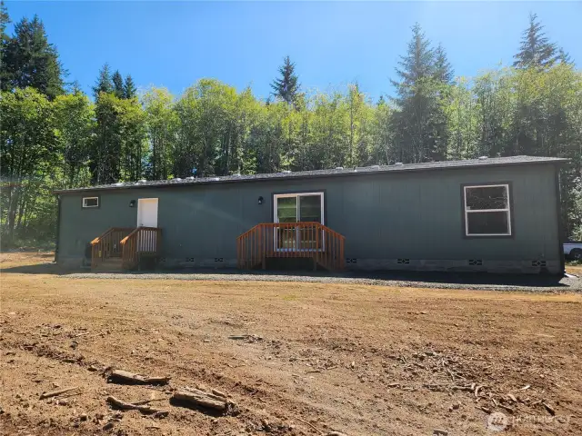 Back side of the home showing back door and slider off the dining area.