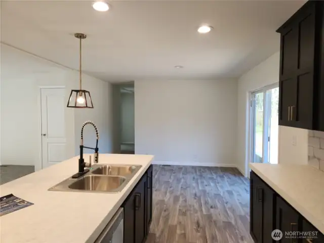 View of dining area from kitchen.  Hallway leads to 2 bedrooms and den/office.