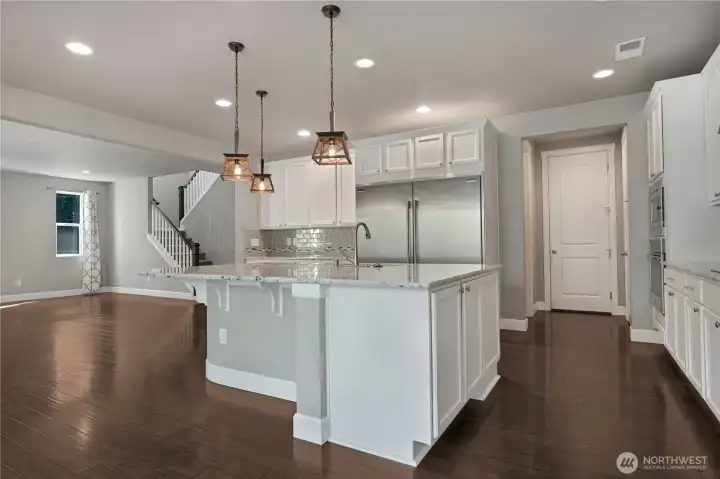 Massive open and inviting kitchen opens up to the living room. This design promotes a sense of spaciousness and connectivity, perfect for both everyday living and entertaining. The layout encourages natural flow between the cooking area and the social zone, creating a warm and welcoming atmosphere for family and guests.