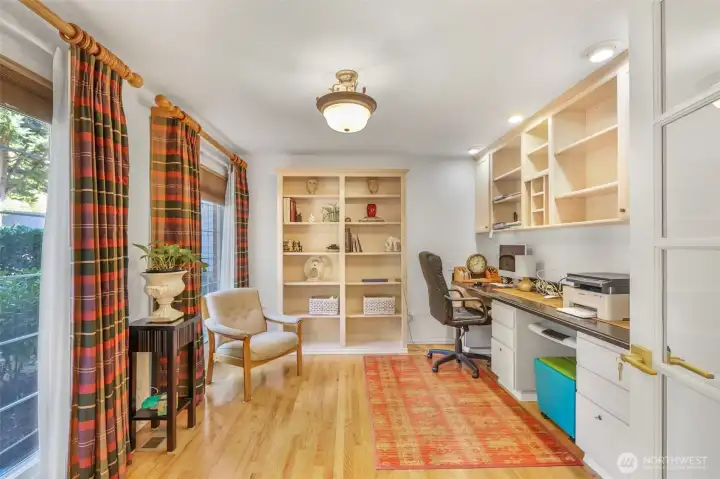 A dedicated home office on the main floor offers privacy and productivity. With custom built-ins, hardwood floors, and large windows, it provides a quiet retreat for work or study.