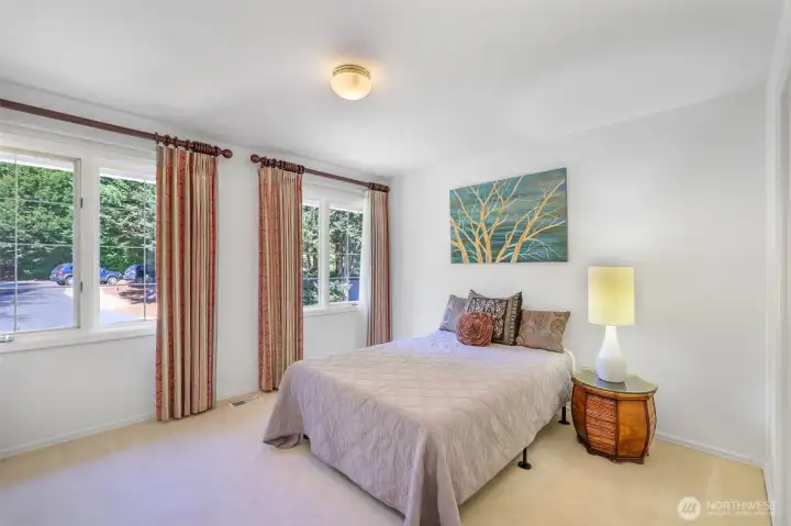 One of three secondary bedrooms, this bright space features large windows and a welcoming atmosphere. Each bedroom in the home is generously sized and designed with comfort in mind.