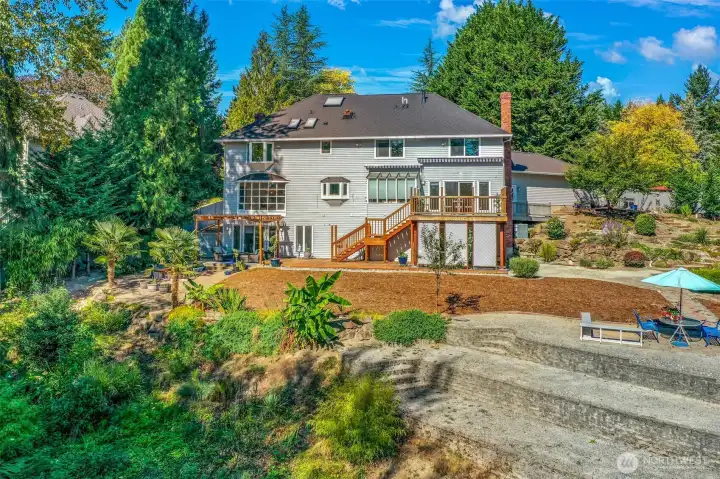 Backyard setting features lush greenery and mature landscaping for privacy and beauty.