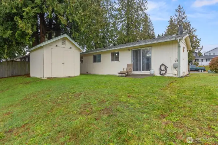 Rear View of Home, Slider & Patio. Backyard slopes to the east. 10 x 12 Detached Shed Perfect for Storage.
