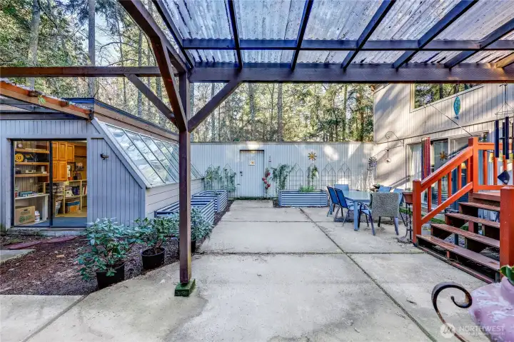View of the courtyard from the front door. Glass house is to the left. Door at the far end leads to the side yard.