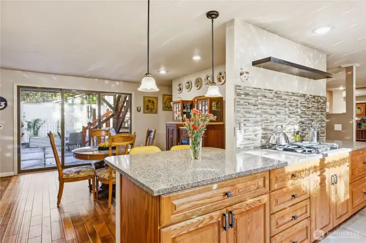 Wonderful kitchen with granite countertops and tiled backsplash behind the gas cooktop.