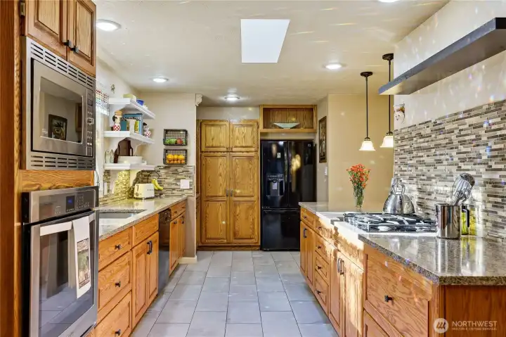 More pantry storage next to the fridge. Microwave and wall oven on the left.