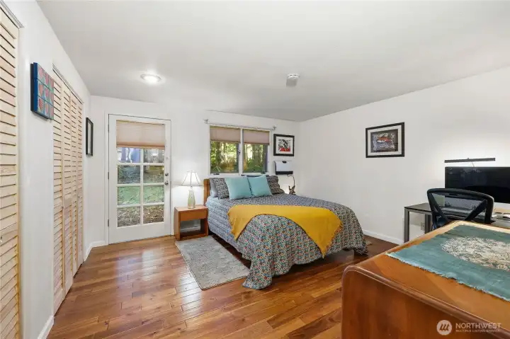 Second bedroom has two closets and a door to the outside. This room has a queen bed and an L-shaped office desk. A heater was added.