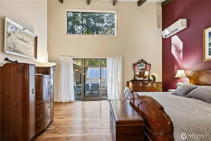 The primary bedroom has a new mini-split, beamed ceiling and large window looking out to trees.