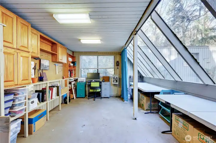 The glass house is currently being used as a studio space with ample storage. This could also be used as a green house for growing plants.