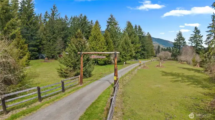 Welcoming Entry with Fenced Pastures on each side of the driveway.