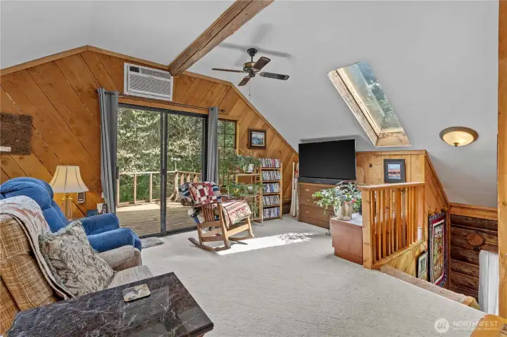 The Upstairs Loft features a Slider to a private Deck, 2 Skylights and wood paneling.
